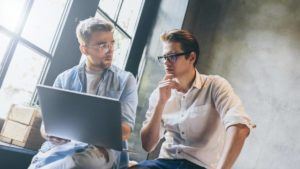two man searching seo agency in the laptop